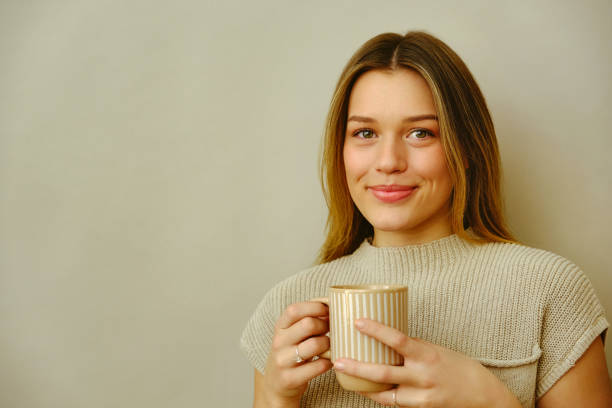 istock Young woman in studio holding coffee 1452669315