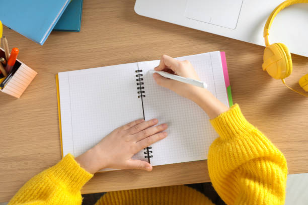 istock Cute little girl with modern laptop studying online at table, top view. E-learning 1452670993
