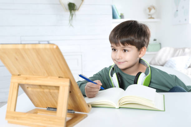 istock Cute little boy with modern tablet studying online at home. E-learning 1452671008