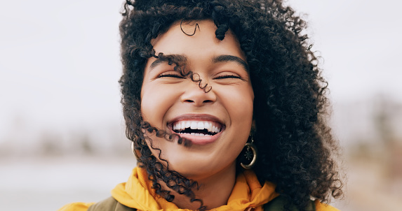 Face, portrait and cheerful black woman outside with fun for travel and explore in winter. African american female, front and laugh at a comic joke while traveling in the UK, England for tourism