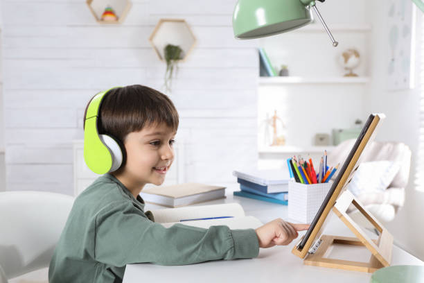 istock Cute little boy with modern tablet studying online at home. E-learning 1452671357