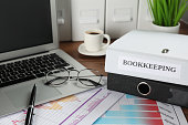 Folders, laptop and documents on desk in office. Bookkeeper's workplace
