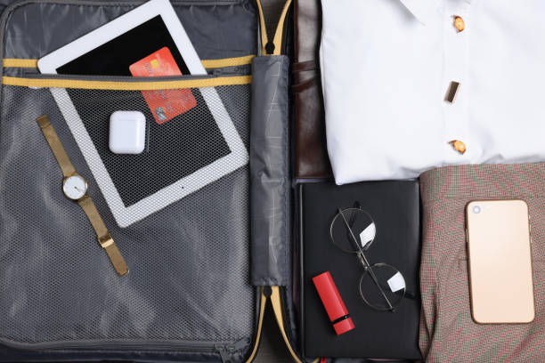 istock Open suitcase with folded clothes and accessories, closeup. Packing for business trip 1452672607