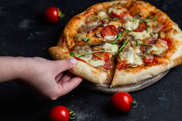 istock Pizza with salami and mushrooms on a dark background 1452677539