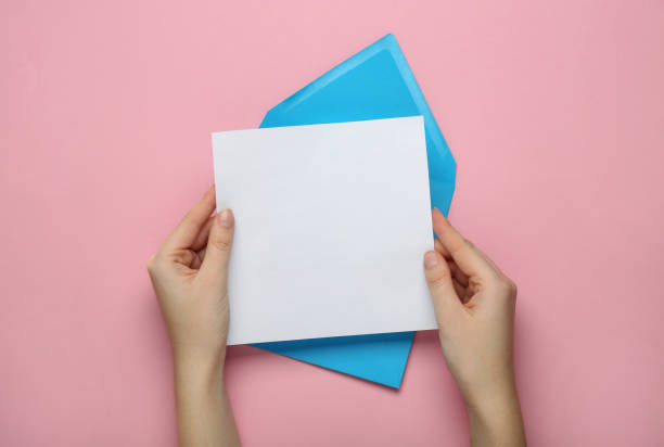 istock Woman holding blank letter on pink background, top view 1452677544