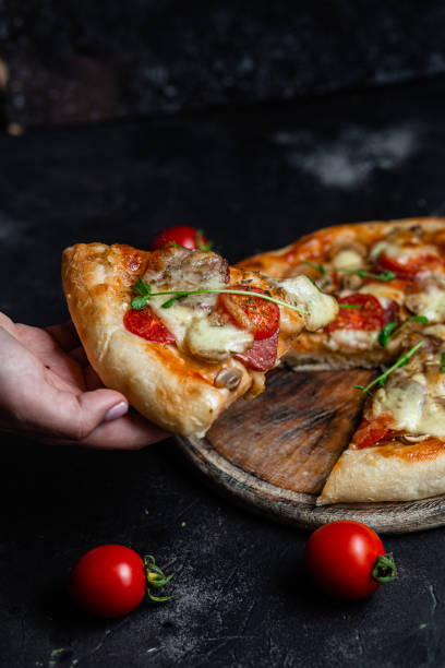 istock Pizza with salami and mushrooms on a dark background 1452677599