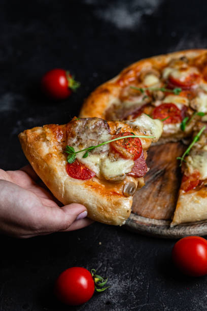 istock Pizza with salami and mushrooms on a dark background 1452677749