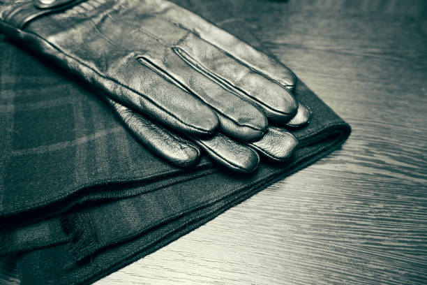 Men's leather gloves and a checkered scarf on the table