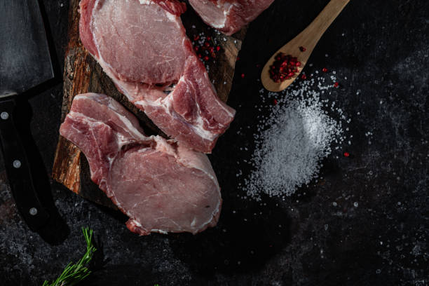 istock Raw pork steak on the bone on a wooden table. Cooking meat 1452678151