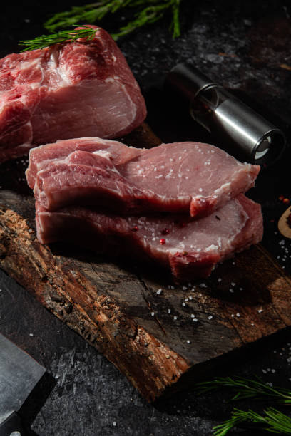 istock Raw pork steak on the bone on a wooden table. Cooking meat 1452678255