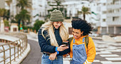 Friends, phone and walking in city, funny meme and social media post, holiday and happy smile, winter and Amsterdam. Diversity, laugh or women with 5g mobile smartphone outdoor with internet content