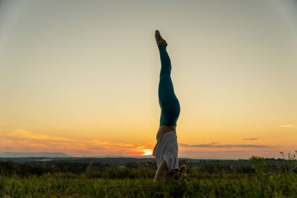 istock Woman practicing headstand on landscape during sunrise 1452680914