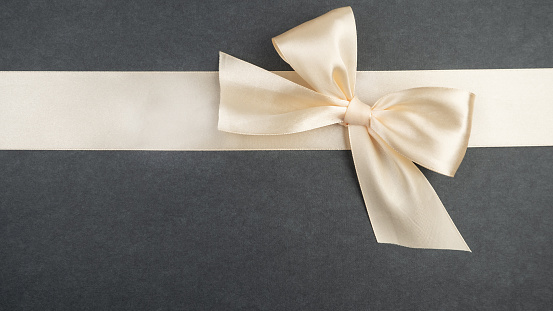 Tied bow and ribbon. Layout for decorating gifts, congratulations, holidays, postcard on a gray background.