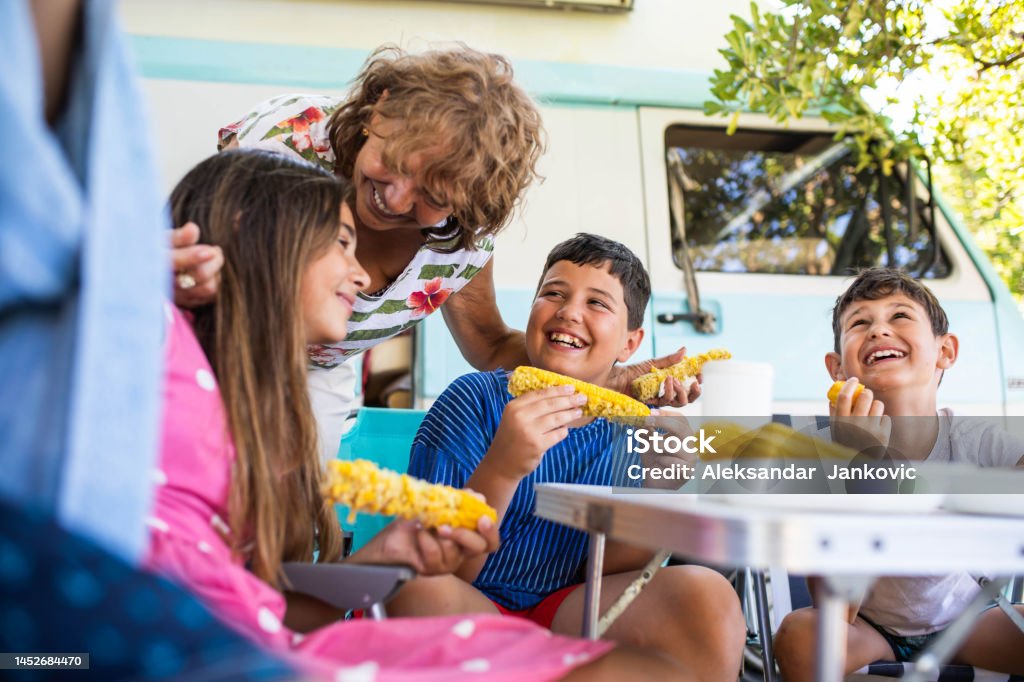 Grandma's favorite A big family is having fun over good food on a seaside camping trip Family Stock Photo
