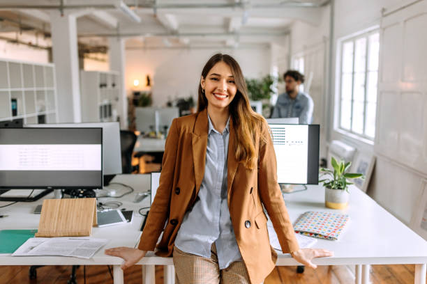 Portrait of young beautiful casually clothed woman in the modern office stock photo