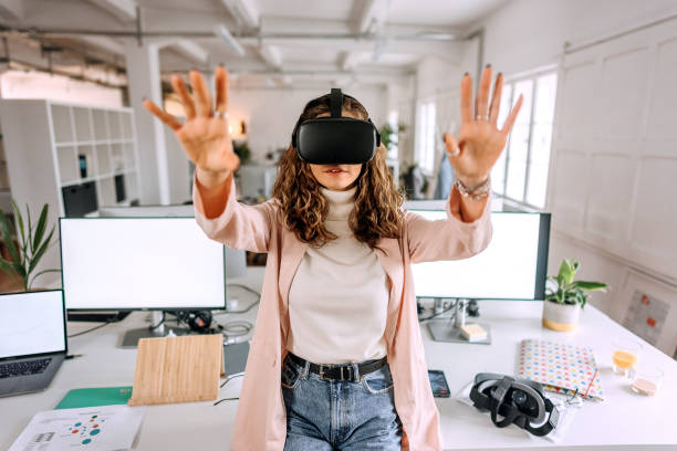 istock Young beautiful woman using VR goggles in the modern office 1452685490