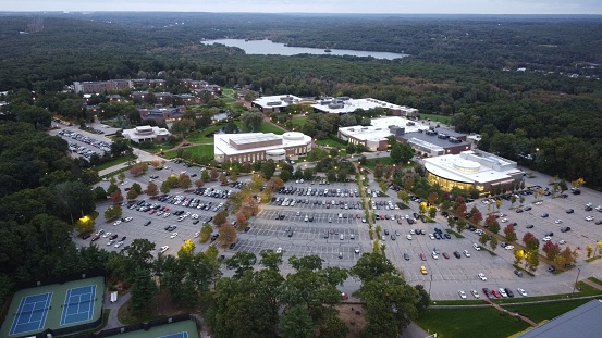 An aerial view of Bryant University and a parking lot with a lake in the background