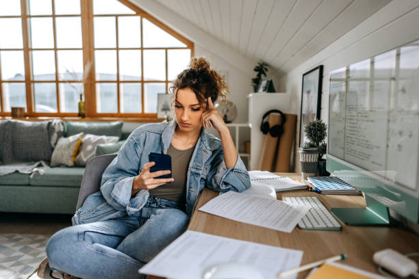 istock Young casually clothed teenage girl text messaging while taking a break from studying at her apartment 1452688400