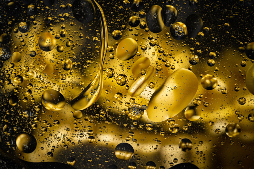 Des gouttes d'huile et d'eau mélangées de couleur or