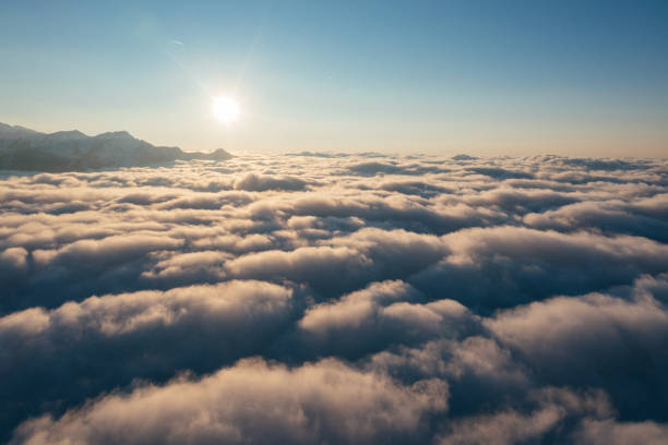 Caucasian mountains above the clouds at the sunset. Cloudscape, aerial view