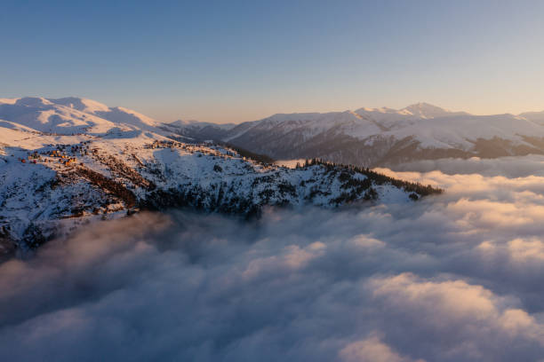 Caucasian mountains above the clouds at the sunset. Cloudscape, aerial view
