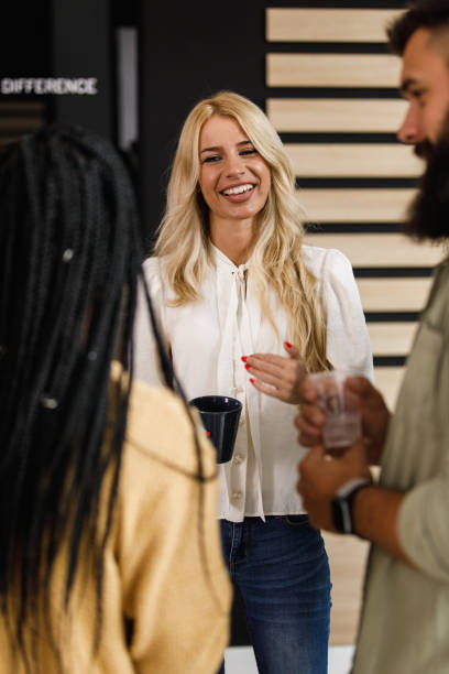 istock Charming blond businesswoman on a coffee break chatting casually with colleagues 1452691227