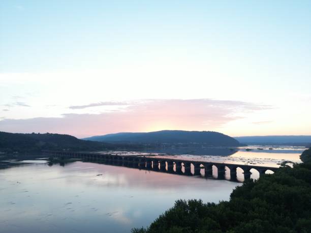 istock Sun setting over the water and a bridge is in the distance 1452691925