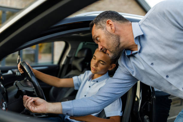 istock Man showing his son how to turn on a turn signal when teaching him basic to drive a car 1452692550