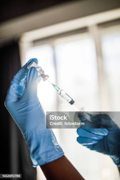 Nurse Wearing Disposable Gloves And Preparing A Vaccine Or A Shot In A Syringe Stock Photo - Download Image Now