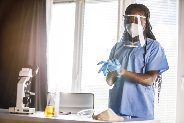 istock Young nurse putting on disposable protective gloves before examining a patient 1452692785