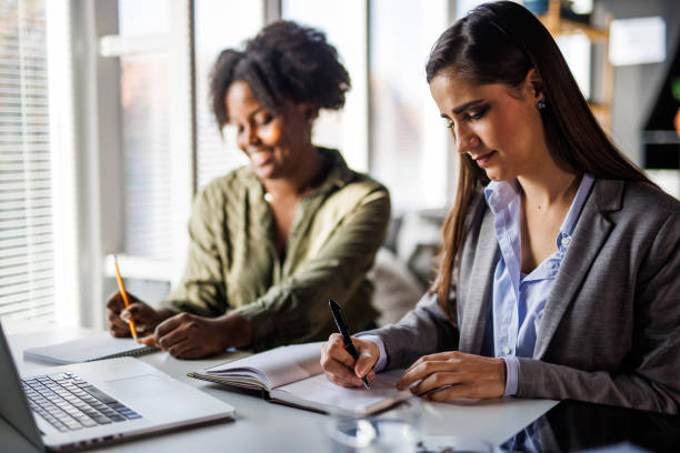 istock Two cheerful young businesswomen co-working on a project together 1452693127