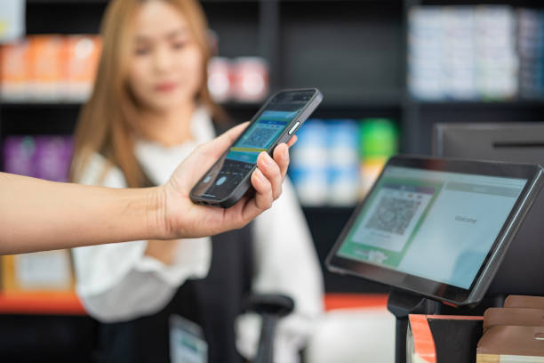 zamknij trzymanie telefonu z ręki, aby zeskanować, aby zapłacić przy kasie w supermarkecie - smart phone china mobile phone asia zdjęcia i obrazy z banku zdjęć