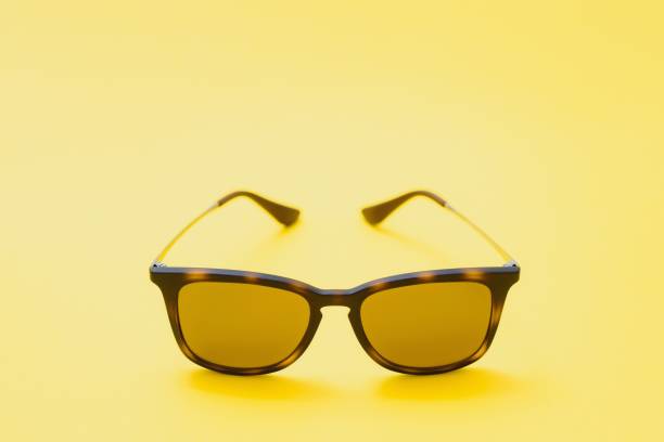 istock Brown glasses on yellow background 1452696450