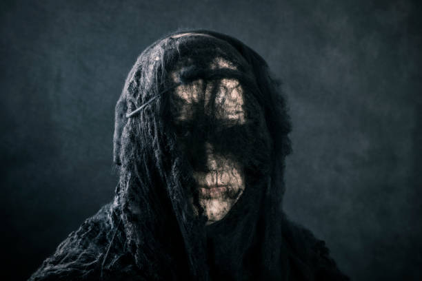 istock Portrait of a scary witch on dark misty background 1452697655
