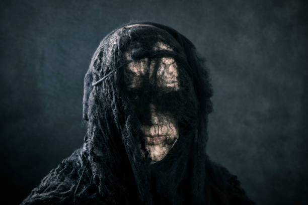 Portrait of a scary witch on dark misty background stock photo