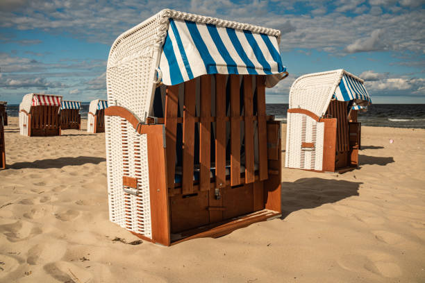 istock Wicker roofed beach chairs at the sand beach. Strandkorb at north seashore. 1452698189