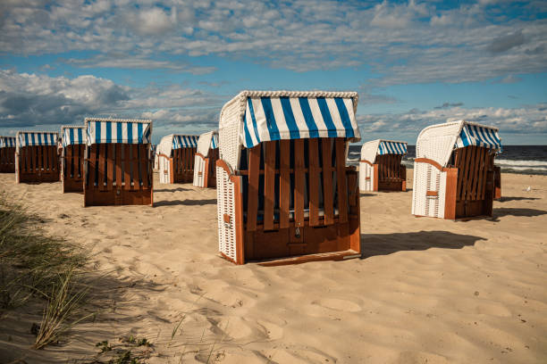 istock Wicker roofed beach chairs at the sand beach. Strandkorb at north seashore. 1452698190