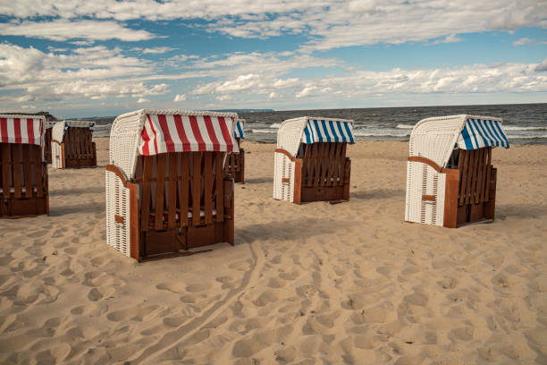 istock Wicker roofed beach chairs at the sand beach. Strandkorb at north seashore. 1452698191