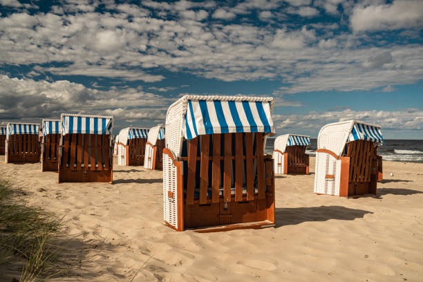 istock Wicker roofed beach chairs at the sand beach. Strandkorb at north seashore. 1452698202