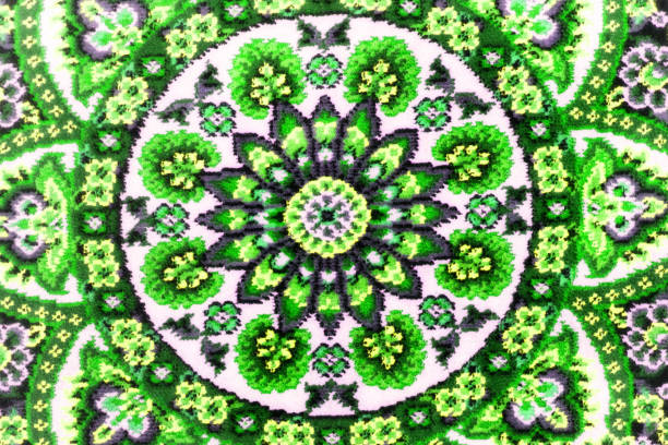 Part of rough woven carpet close-up. Green abstract patterns. Symmetrical background.