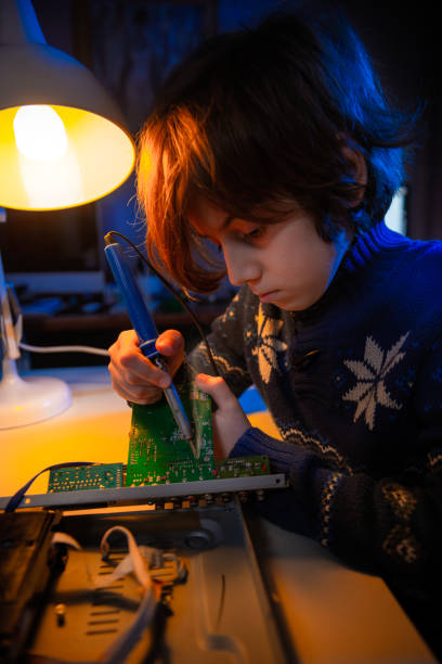istock Little genius boy is fixing an electronic device. 1452703814