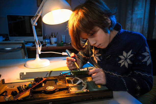 istock Little genius boy is fixing an electronic device. 1452703838
