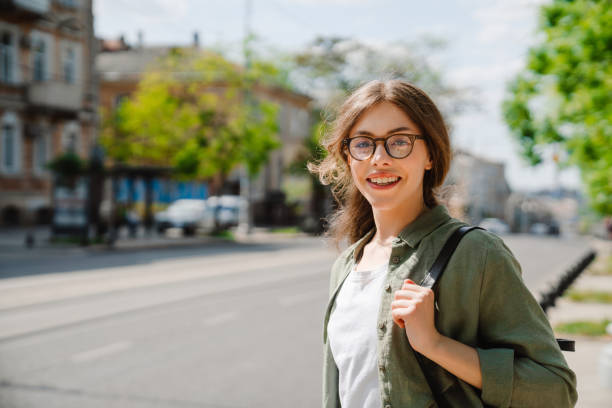 istock Young beautiful smiling happy woman in glasses with backpack 1452712525