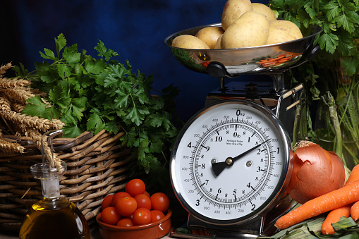 Antique scales with rustic background and vegetables