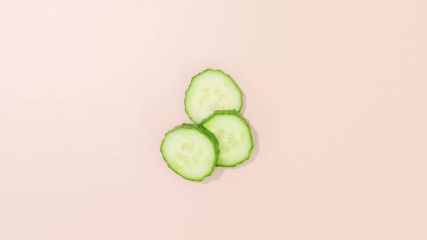 istock Closeup of sliced cucumbers isolated on a pastel surface 1452715167