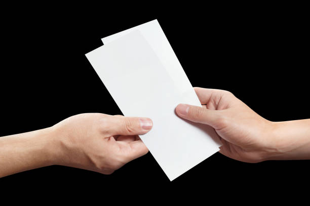 istock Hand sharing two blank sheets of paper on black 1452716466