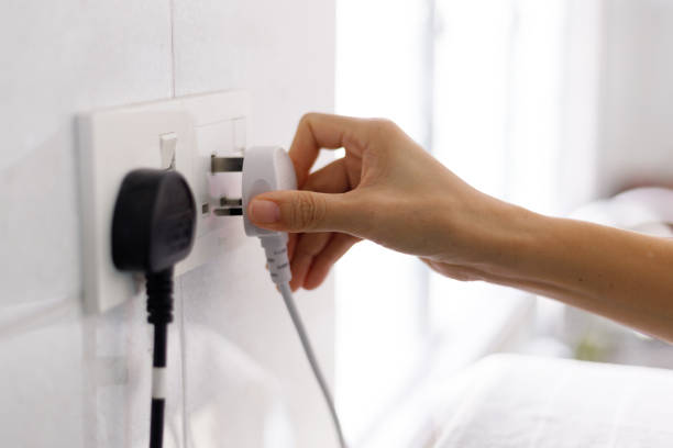 la mano inserisce la spina nella presa elettrica - electric plug outlet human hand electricity foto e immagini stock