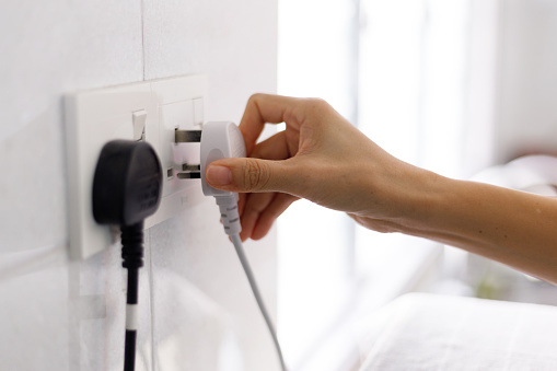 Putting Plug In Hand Puts The Plug Into Electrical Outlet Stock Photo - Download Image ...