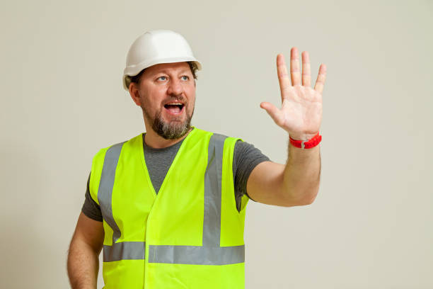 istock worker in a vest and white helmet 1452720862