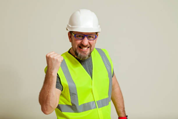 istock worker in a vest and white helmet 1452720871